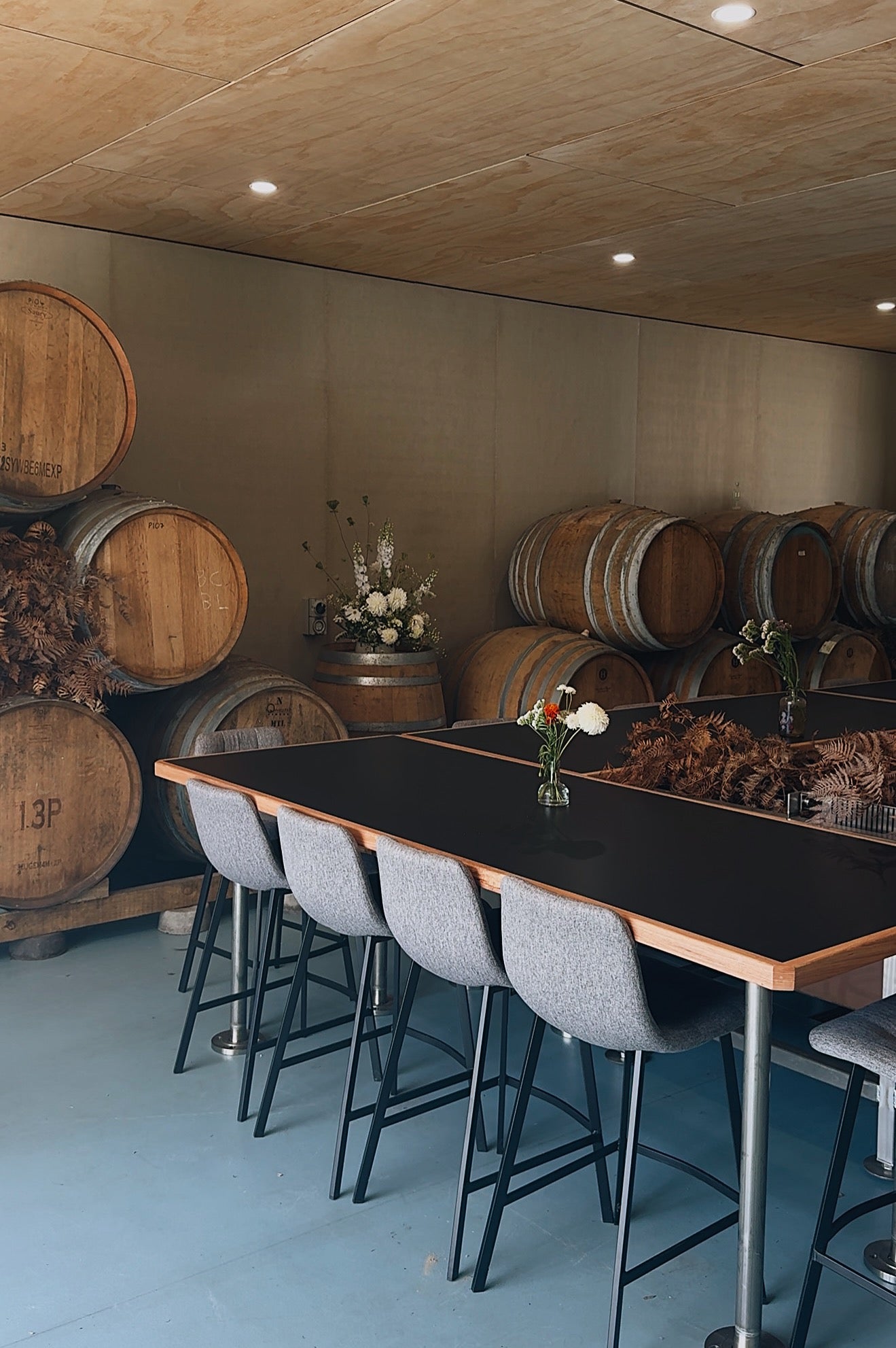 Sailors Grave Brewing "Barrel Room" with wooden barrels and a long table with chairs.