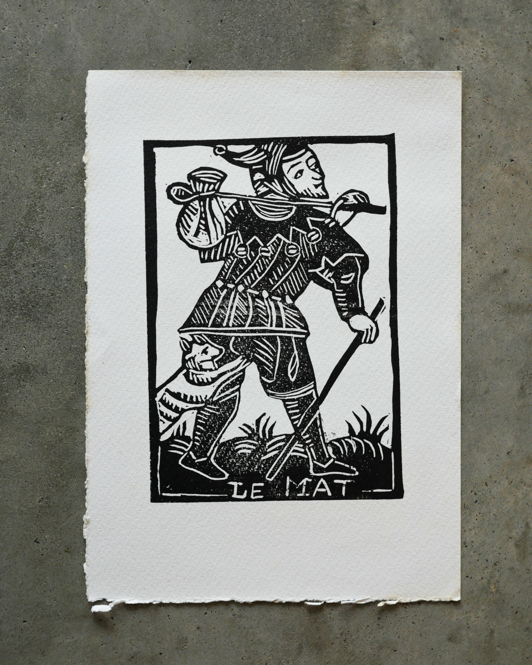 Black and white print of a character labeled 'Le Mat' on a concrete background