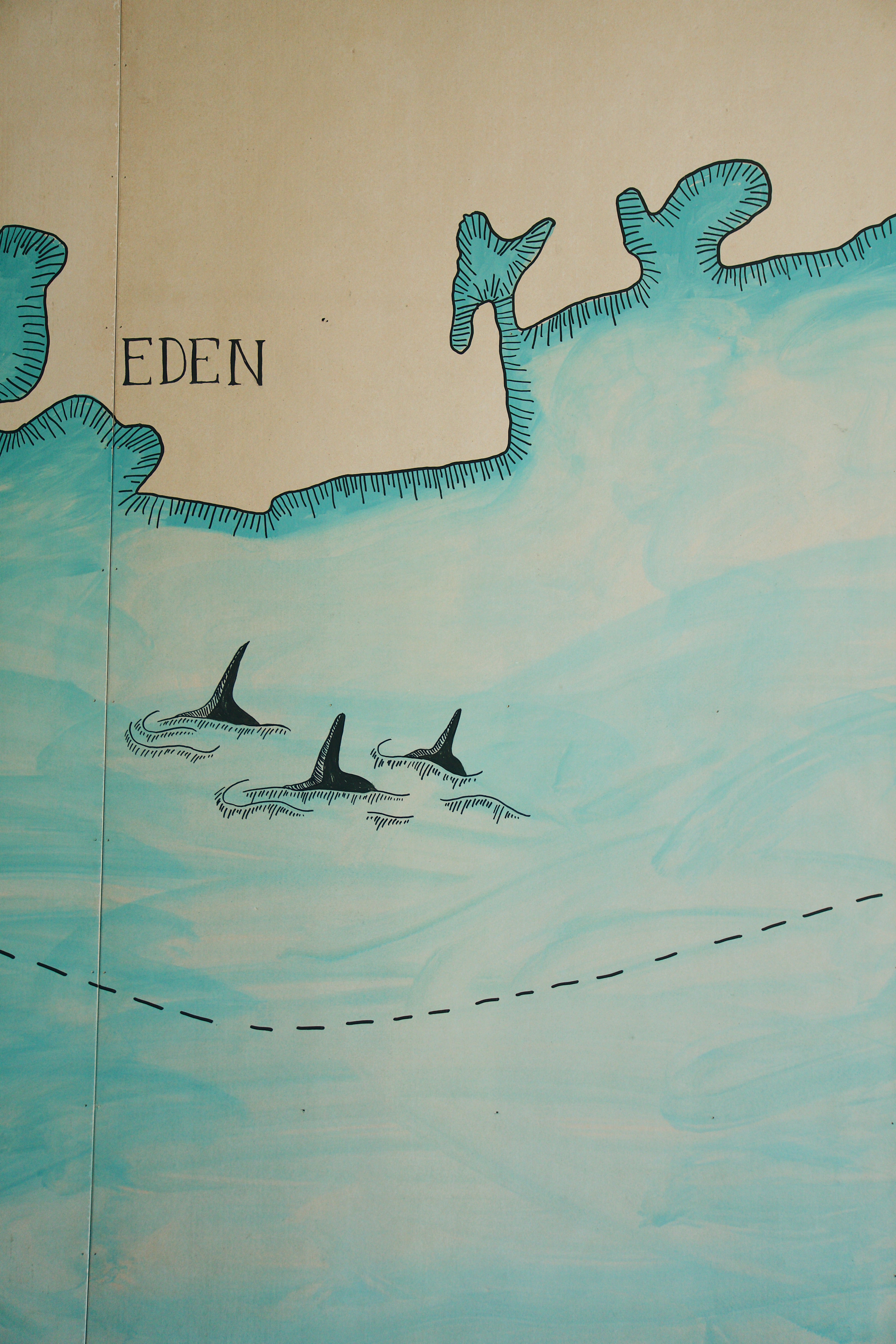 Map of an island named 'Eden' with dolphins in the water